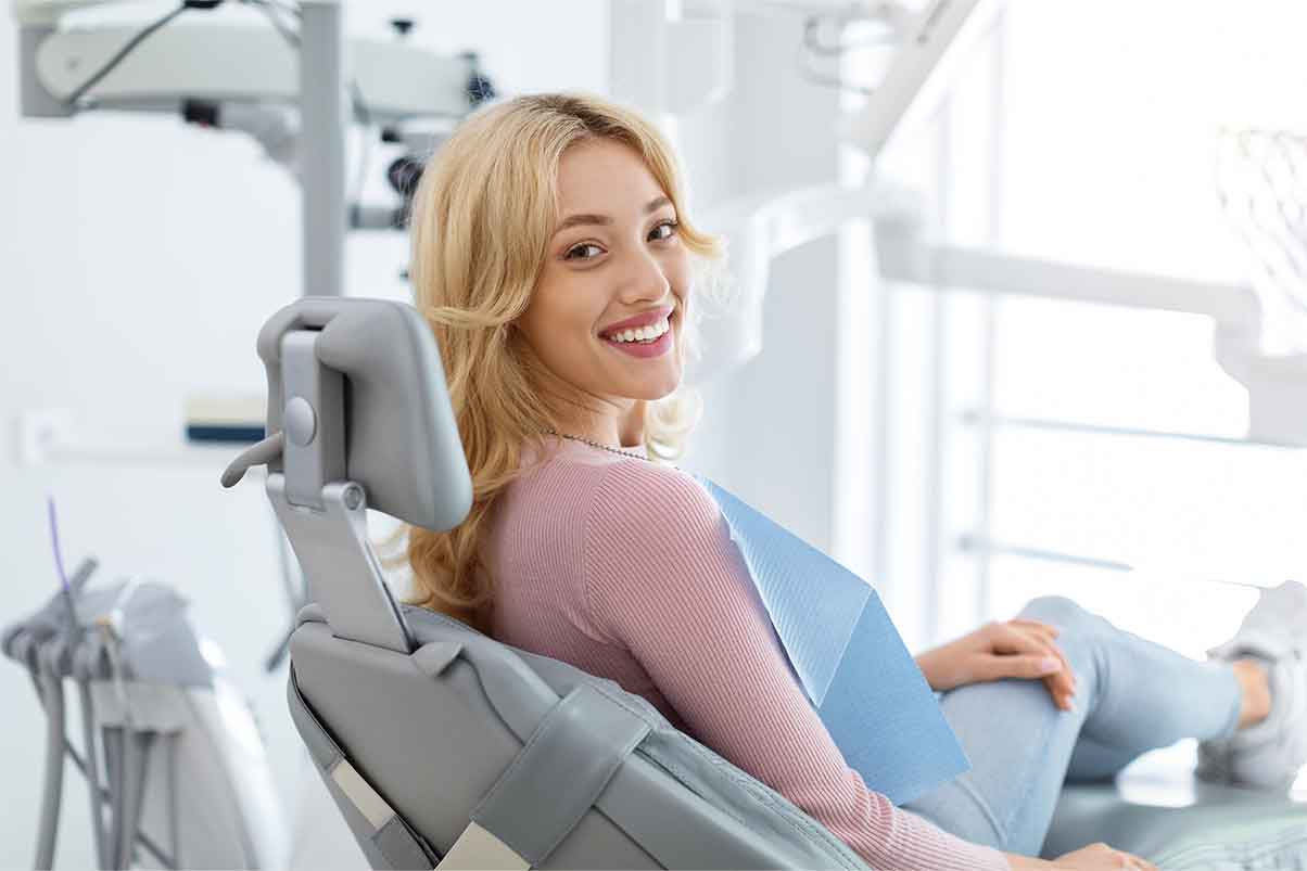 Smiling-and-relaxed-young-woman-sitting-at-dental-chair-1