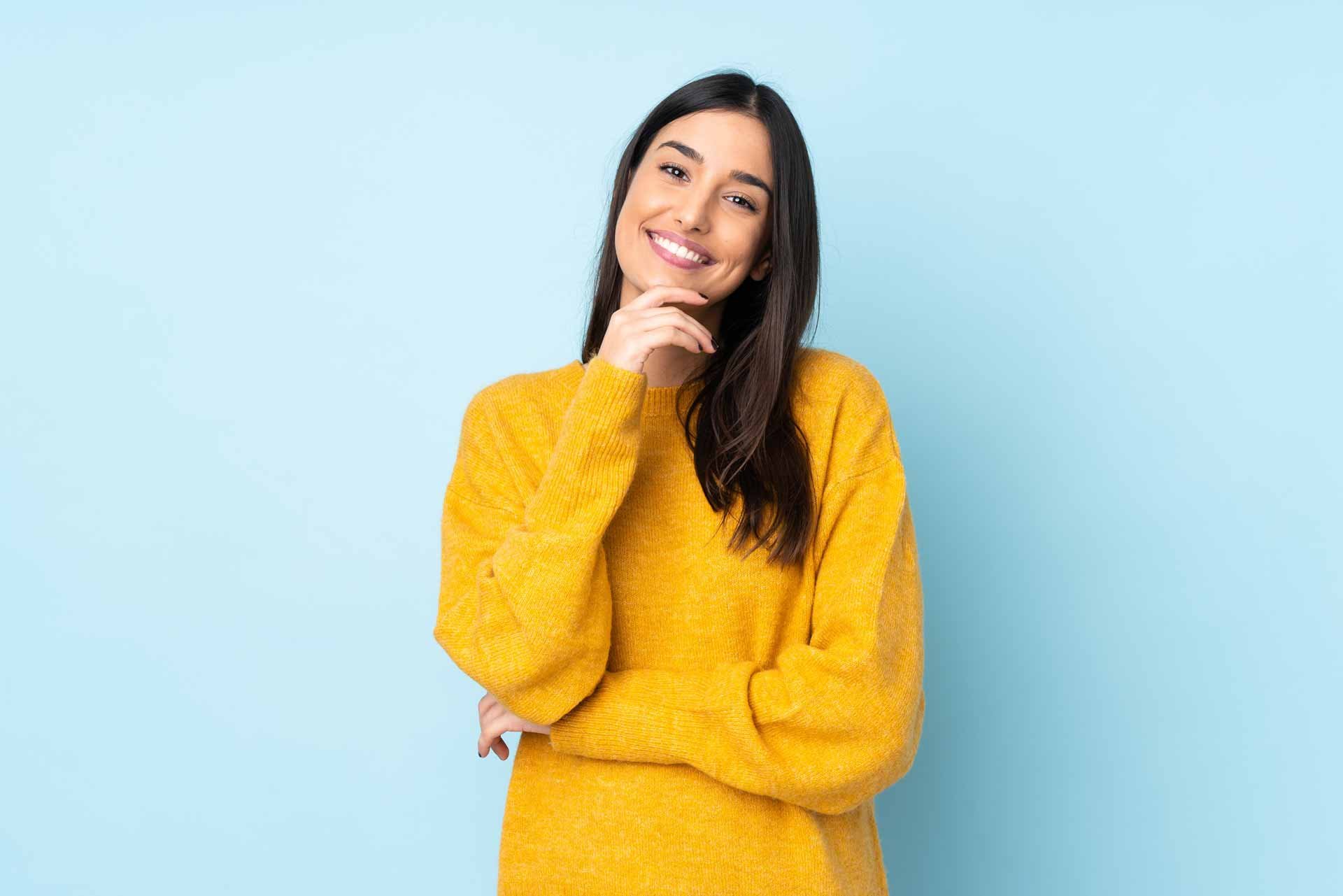 smiling-hispanic-woman-yellow-shirt-on-blue-background