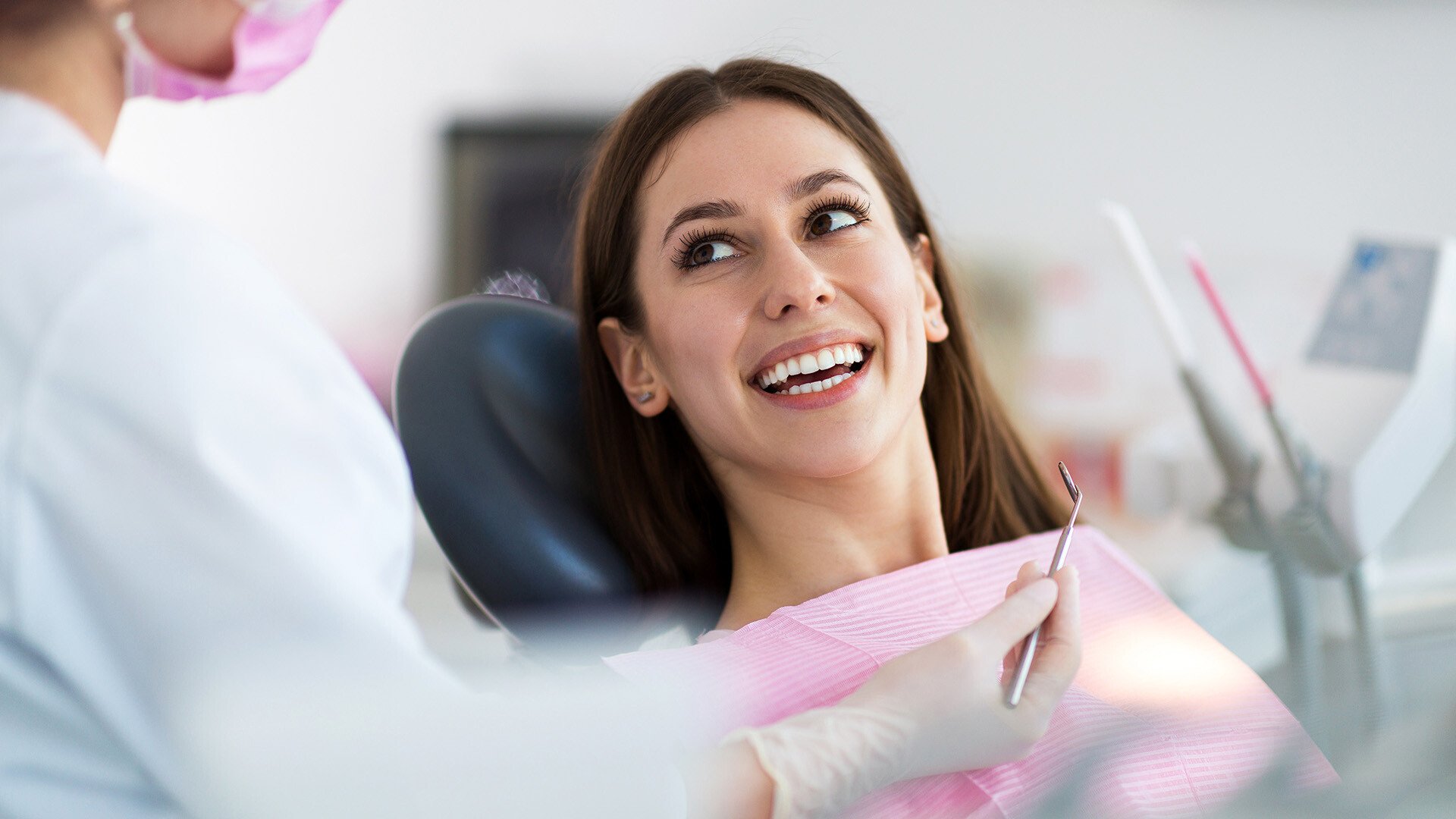 Dental patient in a chair smiling and conversing 