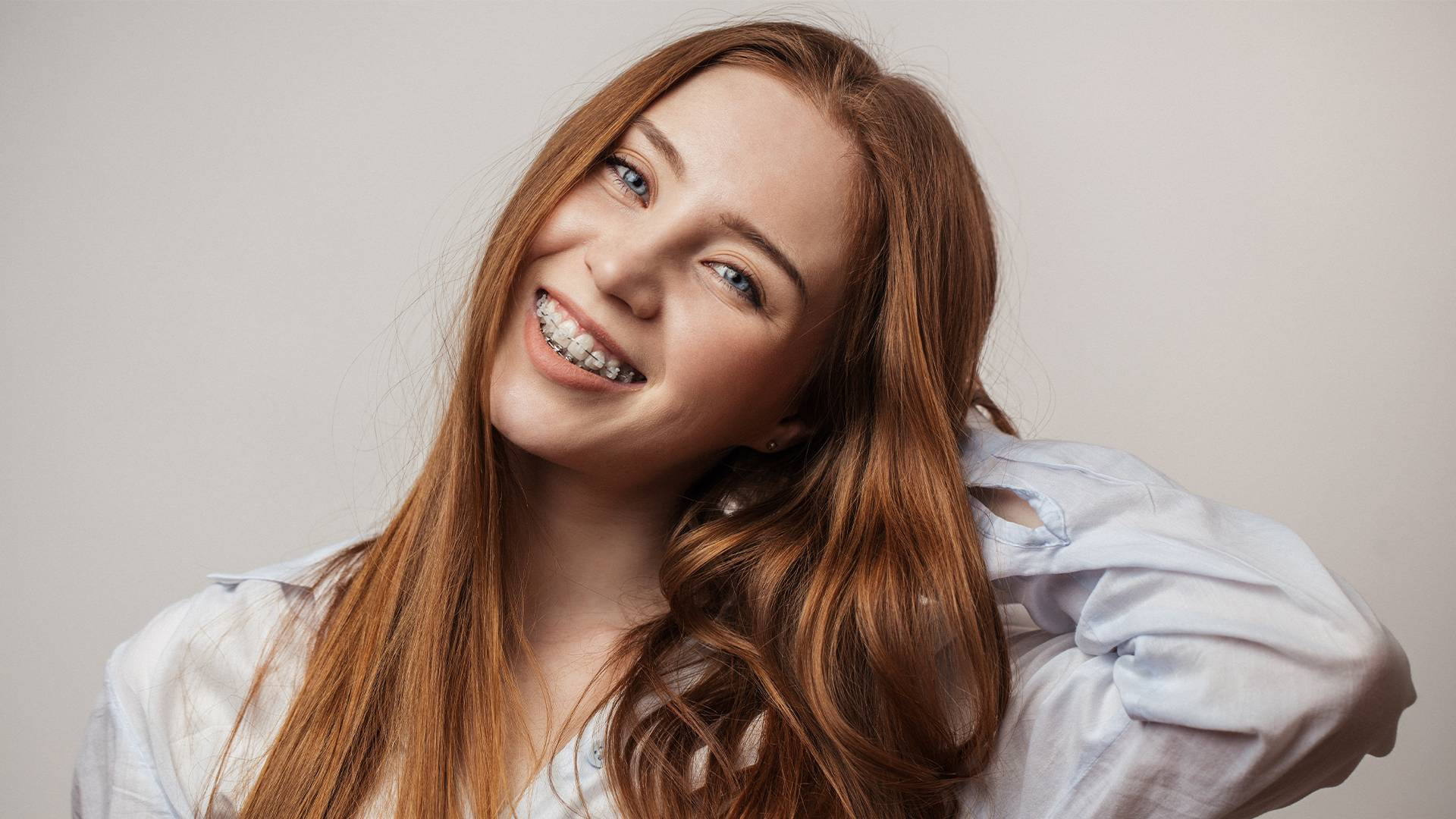 Close up picture of a girl with brown hair and braces smiling